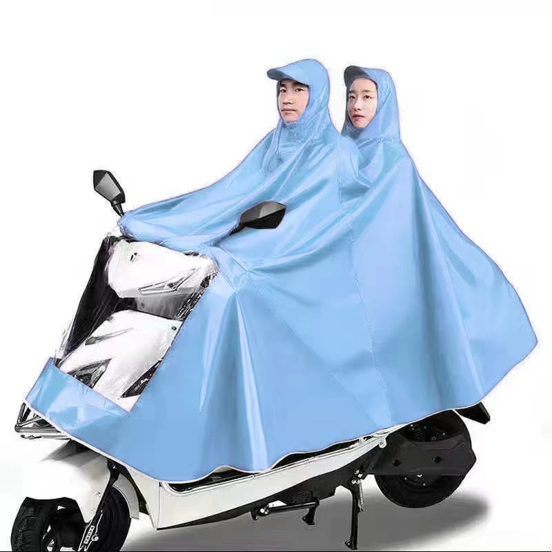 レインコート電気自動車のレインコートを大きくして、オートバイの二人のシングル男性女性が豪雨防止全身に足を隠します。|undefined