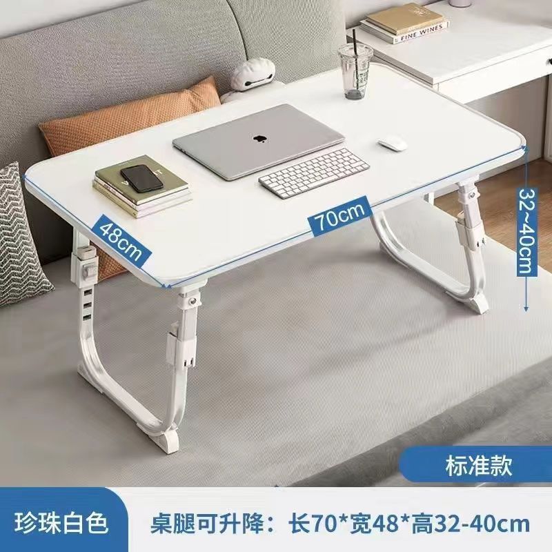 ベッドの上の小さい机のノートパソコンの机の上で折り畳みます。|undefined