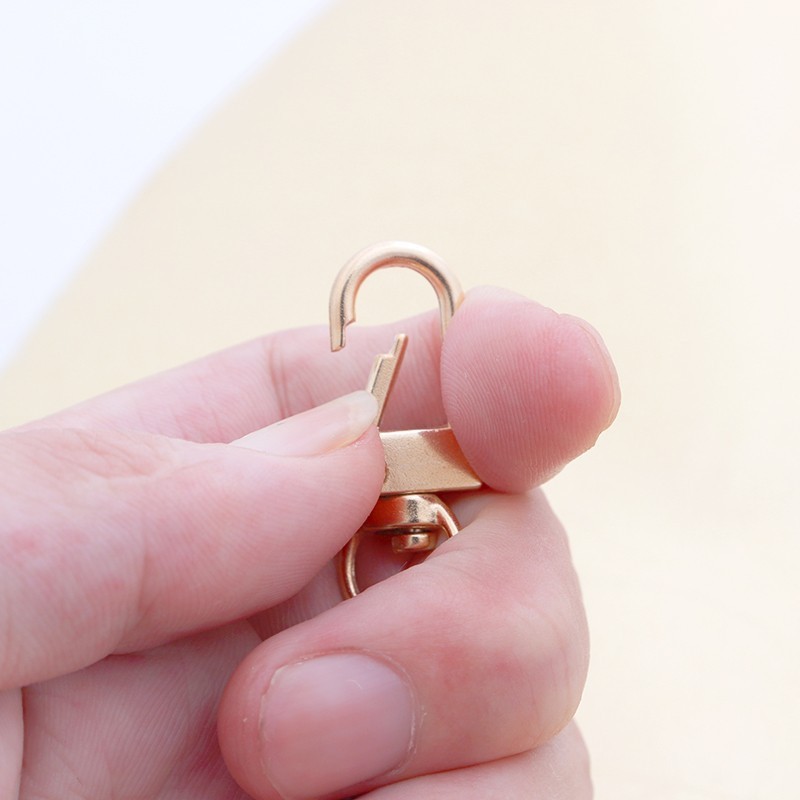 金属のキーホルダーのフックは金色の銃と黒のフックのアクセサリーの部品を掛けます。|undefined