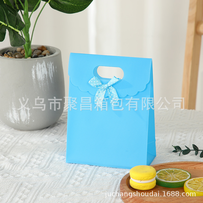 Bolsa de regalo con lazo multicolor, bolsa de mano de polipropileno con tapa abatible, bolsa de regalo con diseño hexagonal tipo ramo.