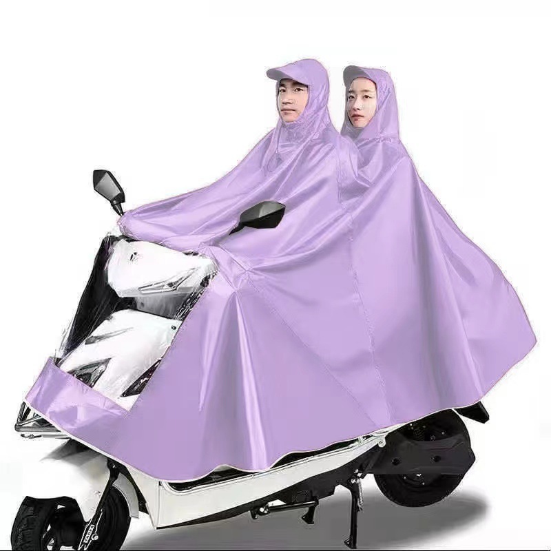 レインコート電気自動車のレインコートを大きくして、オートバイの二人のシングル男性女性が豪雨防止全身に足を隠します。|undefined