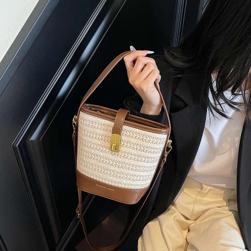 Bolso de cubo de paja de mano popular de verano 2025 nuevo bolso de mensajero tejido de vacaciones junto al mar con textura bolso femenino de todo fósforo