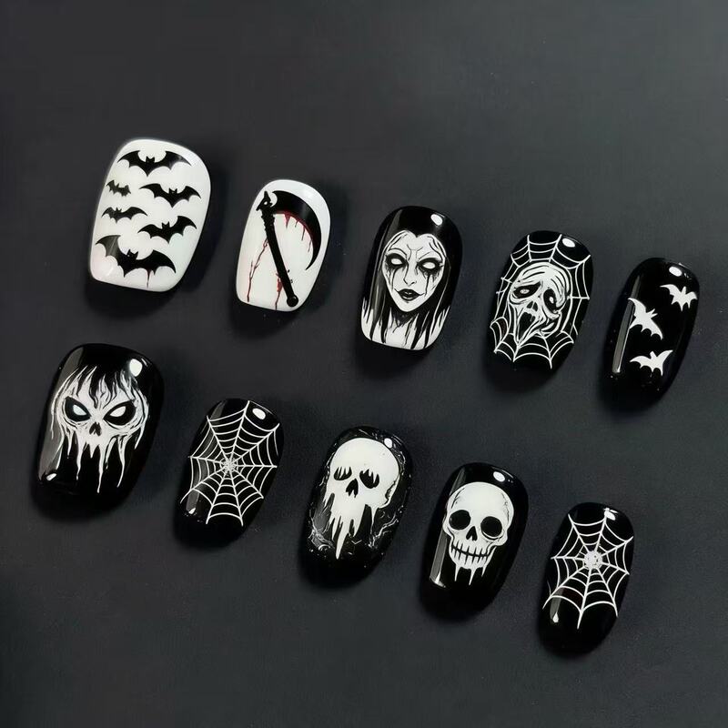 Halloween black and white skull, bat, and spiderweb nail art – short, stylish, and sophisticated fake nails for a spooky atmosphere Halloween black and white skull, bat, and spiderweb nail art – short, stylish, and sophisticated fake nails for a spooky atmosphere