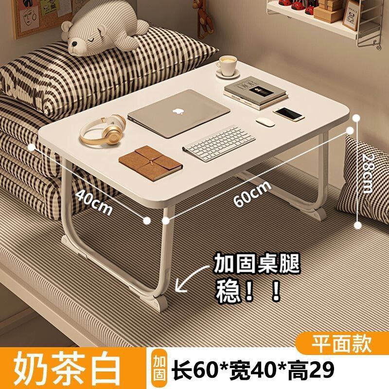 ベッドの上の小さい机のノートパソコンの机の上で折り畳みます。|undefined