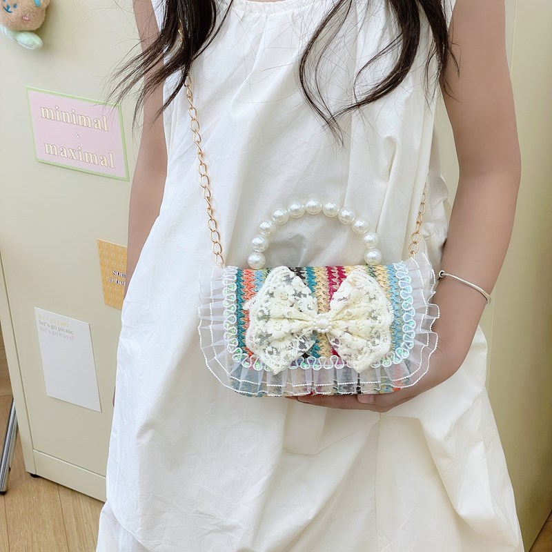 2025 verano nuevo arco de paja bolsa de perla portátil inclinada pequeña fragancia bolsa de moda para niños mochila para niñas