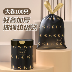 家庭用の手で厚い黒色のプリントゴミ袋を持っています。
