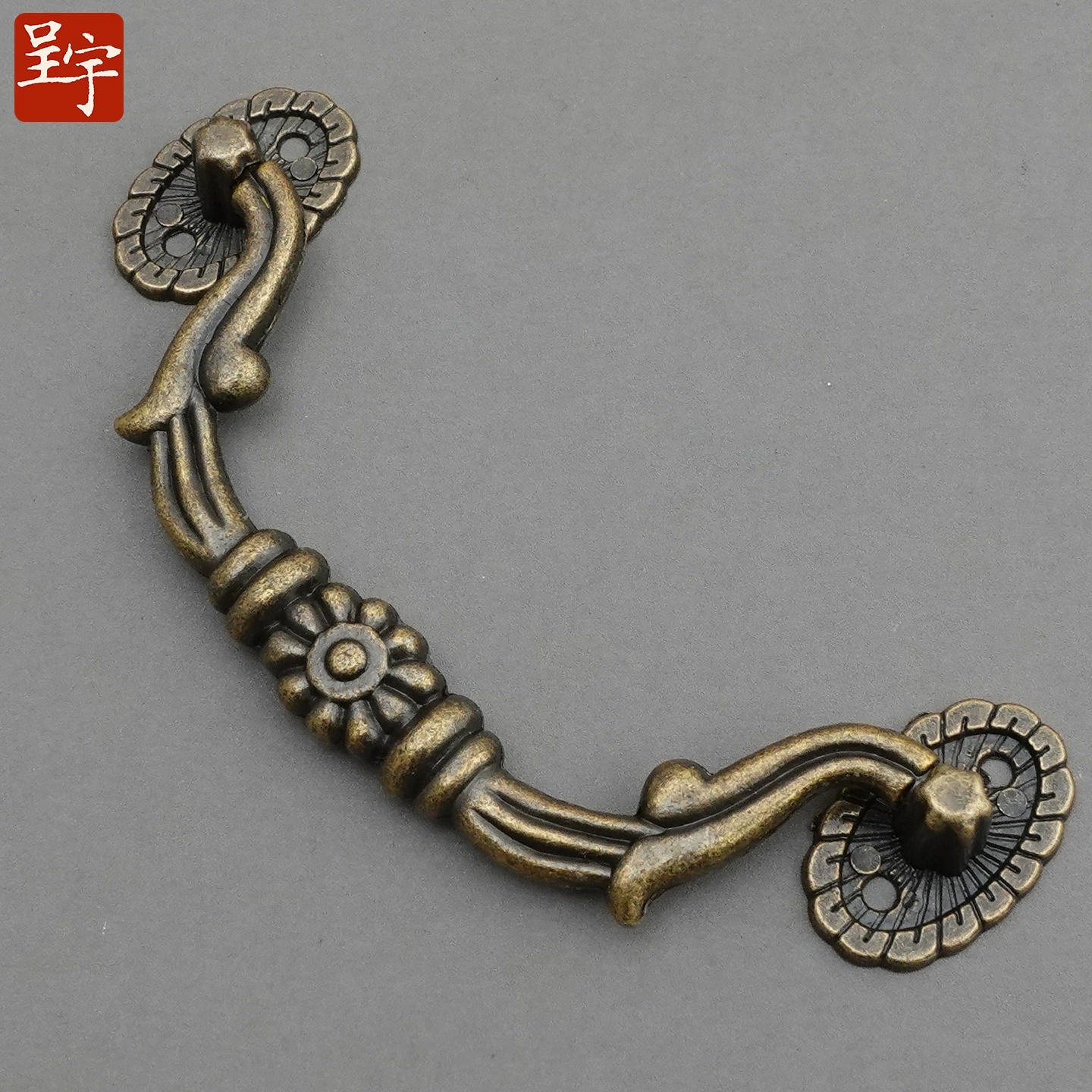 Antique‑style metal drawer handle, decorative bronze/golden finishes, multiple motifs