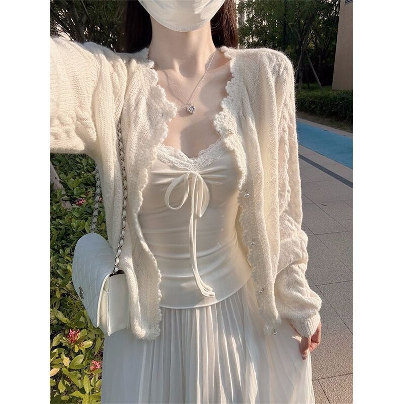 Gentle and elegant knitted cardigan with a round neckline, a beautiful sweater-style outerwear piece featuring crochet detailing, a cream-colored hue, pearl buttons, and a handmade white finish Gentle and elegant knitted cardigan with a round neckline, a beautiful sweater-style outerwear piece featuring crochet detailing, a cream-colored hue, pearl buttons, and a handmade white finish