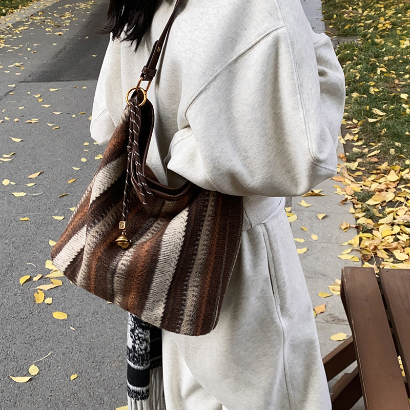 Bolsa de cubo de tendencia coreana a rayas, bolsa de hombro de gran capacidad, otoño y invierno 2025, nueva bolsa de mochila casual para mujeres.