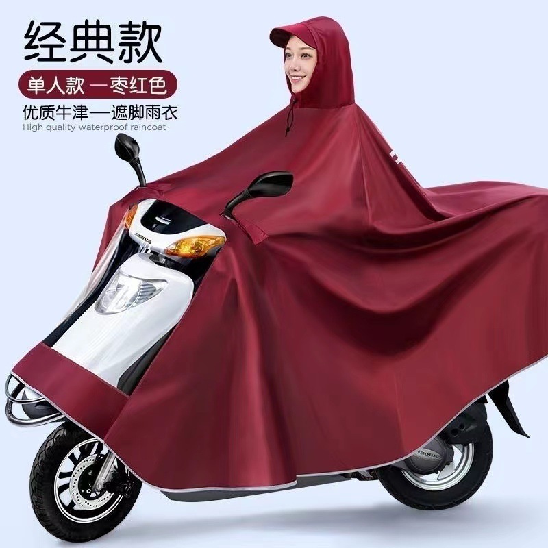 レインコート電気自動車のレインコートを大きくして、オートバイの二人のシングル男性女性が豪雨防止全身に足を隠します。|undefined
