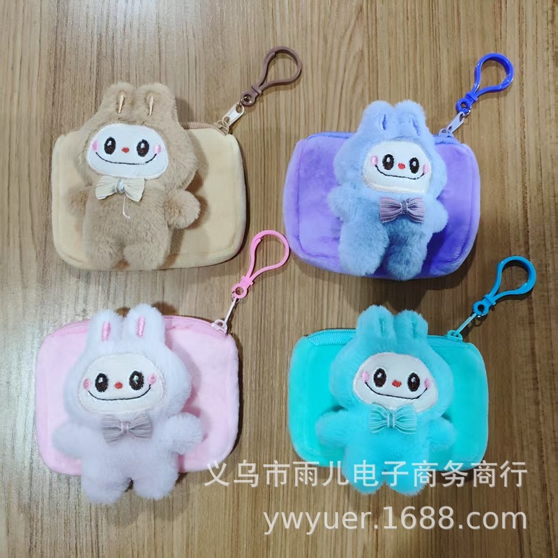 震え音の赤い本が爆発してかわいいぬいぐるみの布の小銭入れのキーホルダーのイヤホンのかばんにプレゼントを掛けます。|undefined