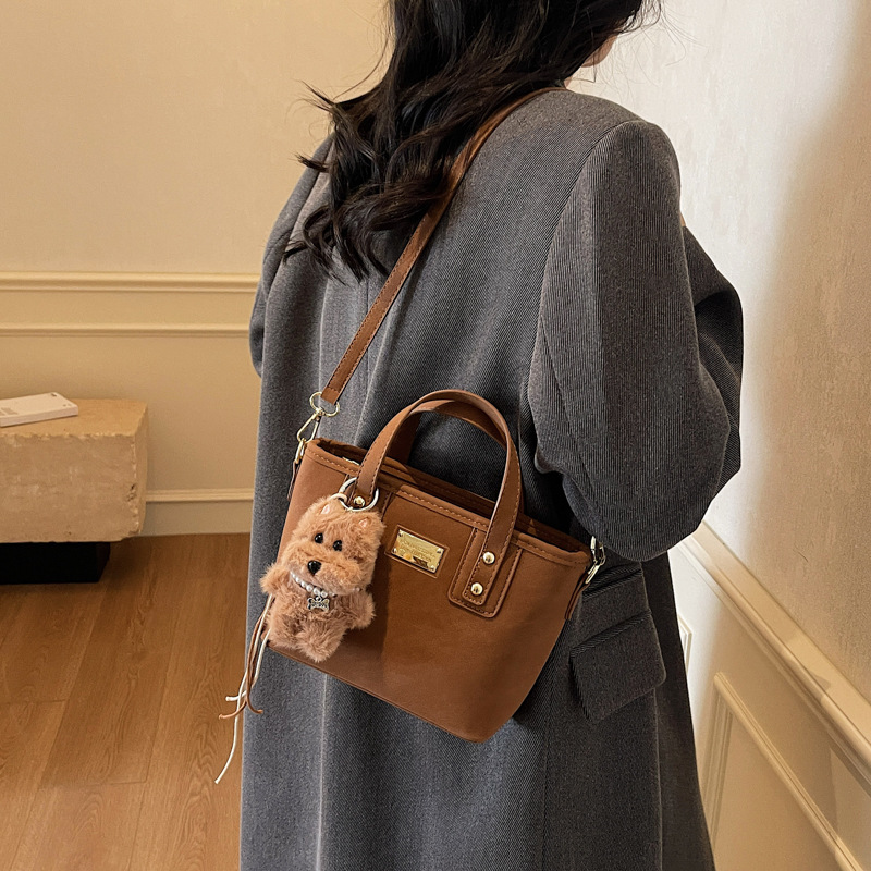 Alta sensación retro esmerilado bolso de cubo portátil 2025 otoño y invierno nuevo bolso de hombro de mujer de viaje versátil mochila