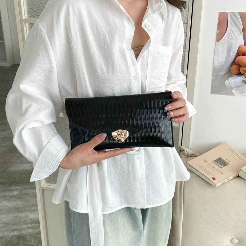 2026 primavera nuevo sobre ligero de lujo bolso de mano de mujer simple botón de metal de moda bolsa de banquete de temperamento casual