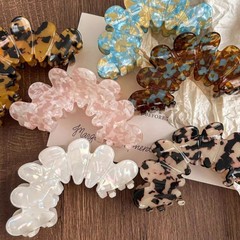 酢酸の花びらが女性をつかみます。2025年の新型の高級感の後頭部の髪の気質のサメの髪を挟みます。