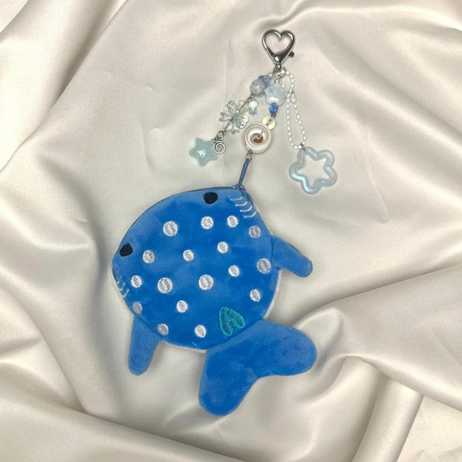 The factory produces cartoon shark coin purses, plush zipper bags, data cable bags, decorative pendants, and small gifts for children.