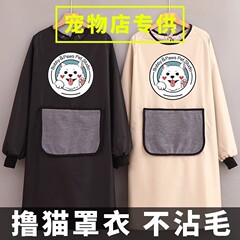 猫専用服の毛がくっつかない防水ペットショップの長袖エプロンで猫服を抱いています。