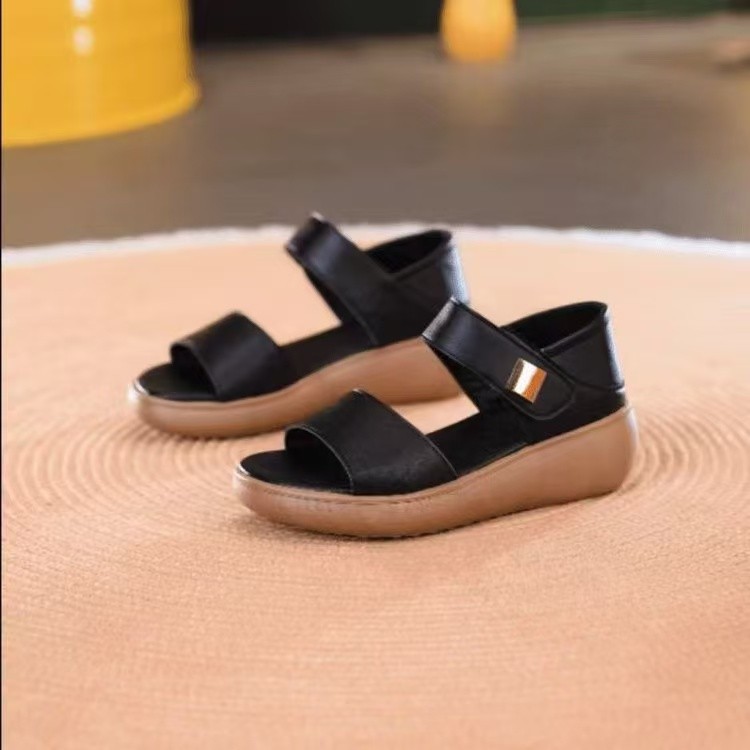2026 verano nuevo cuero suave con una palabra con sandalias de talón de pendiente para mujeres Velcro ligero antideslizante zapatos casuales de mediana edad