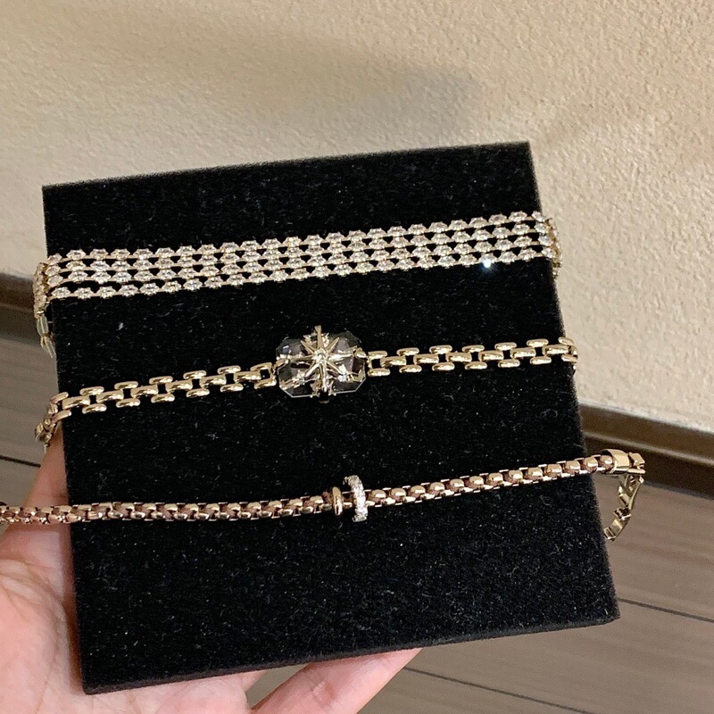 Trendy light coffee-colored gold bracelet, featuring multiple layers of cubic zirconia, a star-shaped charm, and a design that allows it to be worn with a watch chain, creating a luxurious and sophisticated look