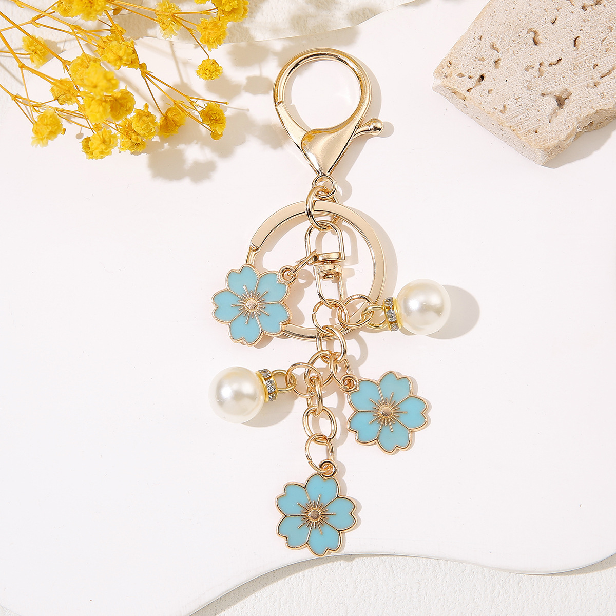 Venta al por mayor de llaveros de flores de cerezo japoneses que caen a mano, adornos de bolsos de mujer que gotean aceite, colgantes de perlas para parejas de novias