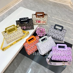 国境を越えた対外貿易の新しいファッションは流行のアルファベットを手にして特包を持って肩を斜めに掛けてデザイン感のある女性バッグを持っている