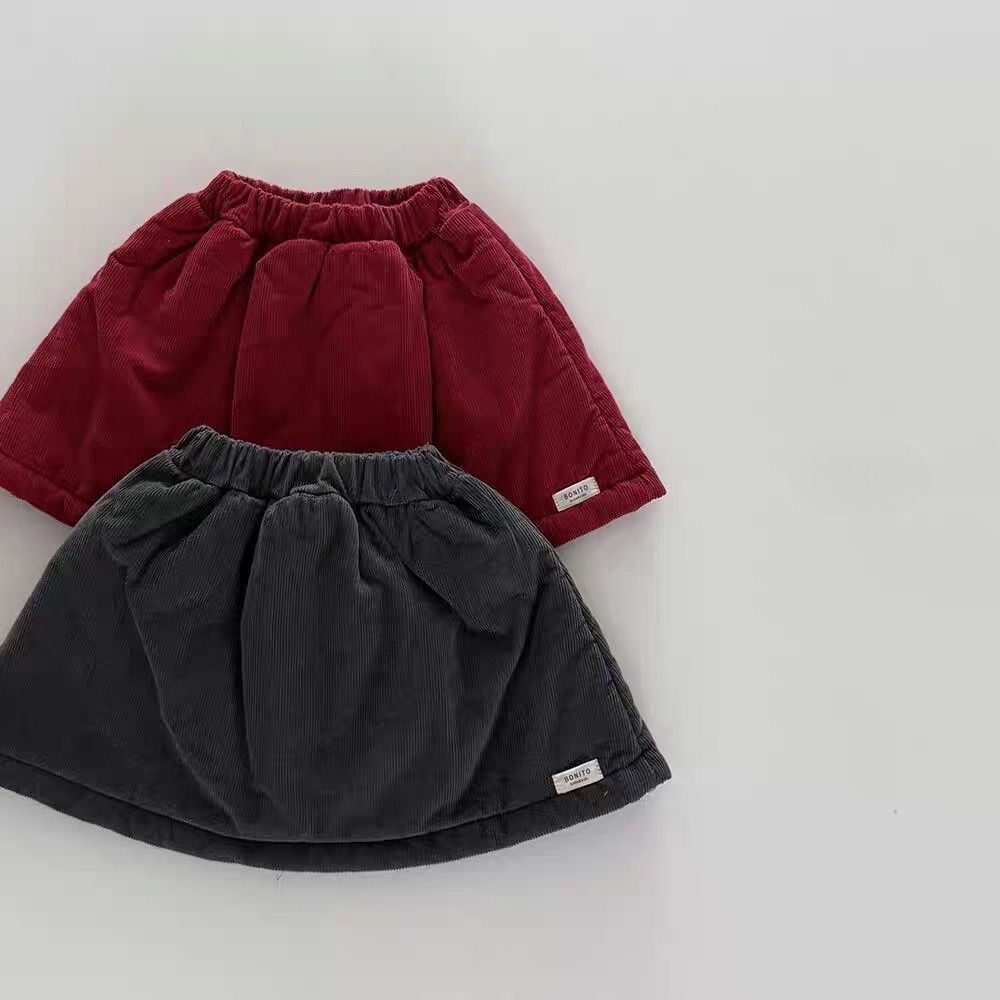 Niñas coreanas falda de algodón intercalado de otoño / invierno 2025 falda corta para niños de color sólido universal Año Nuevo falda gruesa