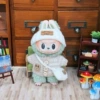 Brown sweater, white hat, bag