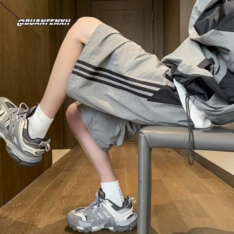 Pantalones cortos de secado rápido estadounidenses para hombres 2025 nuevos pantalones casuales de verano a rayas de cinco puntos tendencia deportiva suelta