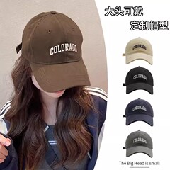 野球帽の女性は夏に大きな頭をかぶって帽子をかぶっています。
