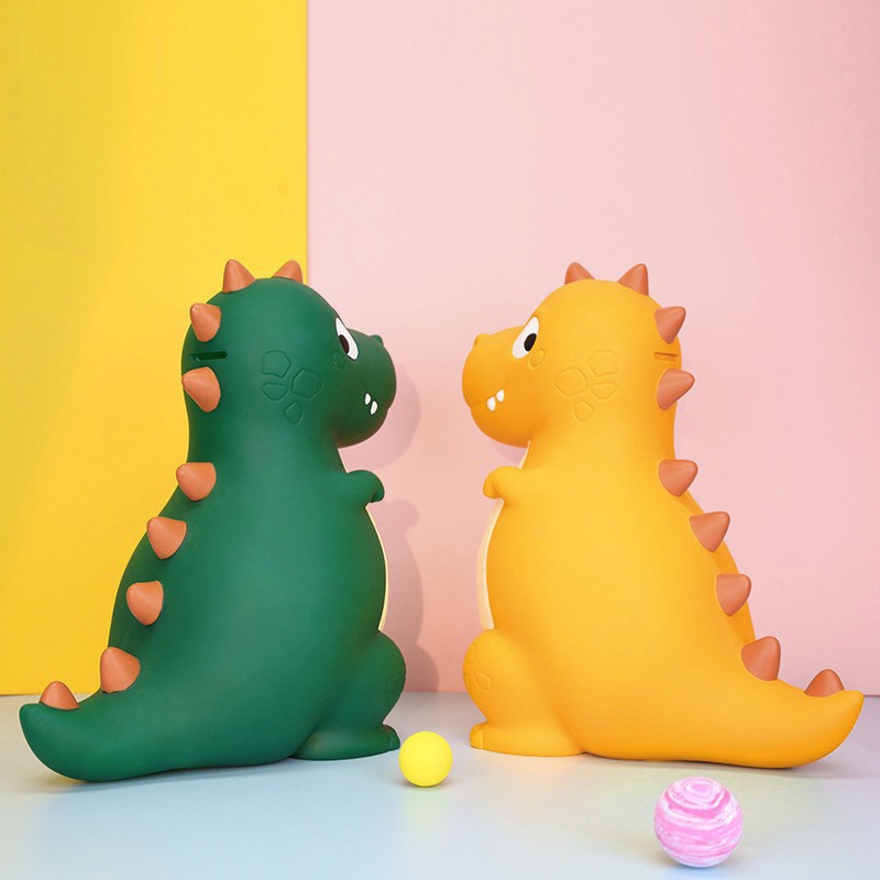 La decoración del hogar de la alcancía de los niños lindos de dibujos animados transfronterizos puede entrar y salir de la alcancía de dinosaurio resistente a la caída