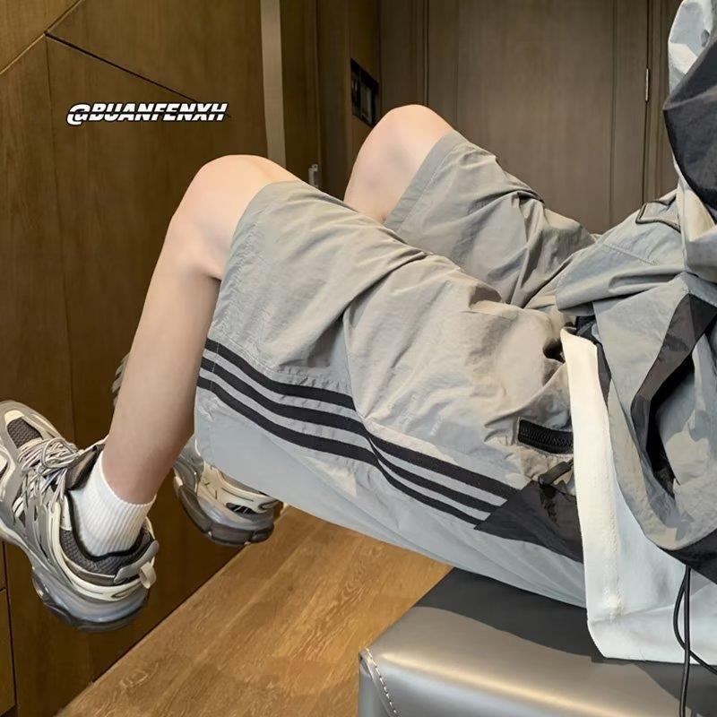 Pantalones cortos de secado rápido estadounidenses para hombres 2025 nuevos pantalones casuales de verano a rayas de cinco puntos tendencia deportiva suelta