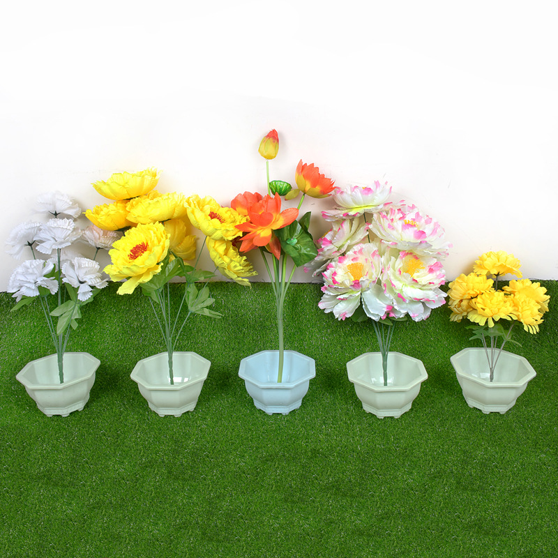 Simulated chrysanthemum bouquets on the graves and pots in the…