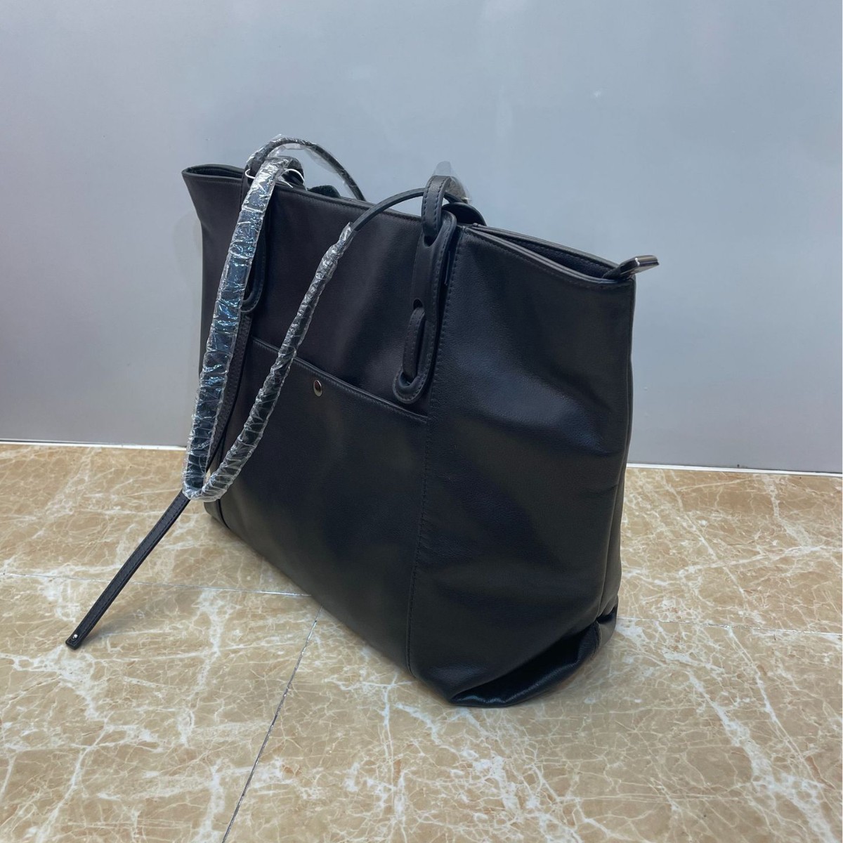 El nuevo bolso tote tiene un temperamento negro simple, cuero suave, bolso de hombro único, bolso de cercanías y bolso de gran capacidad.