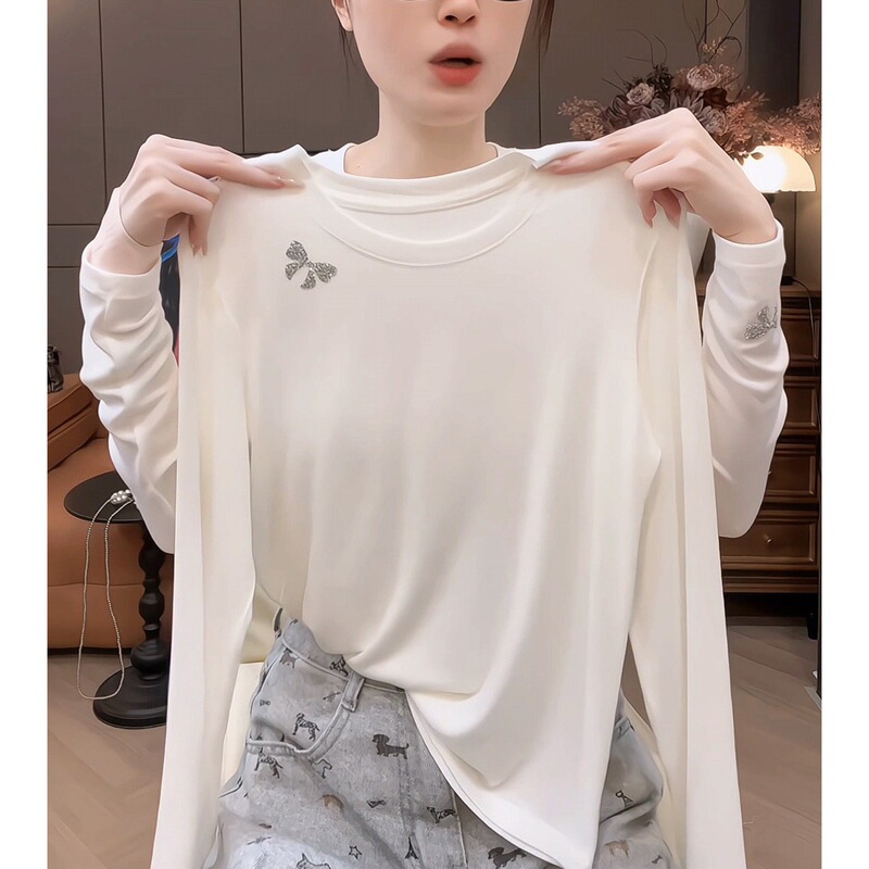White crew-neck, versatile, fitted, long-sleeved T-shirt for women, with a soft, comfortable feel, a bow detail, and rhinestone embellishments, perfect as an inner layer or top for autumn