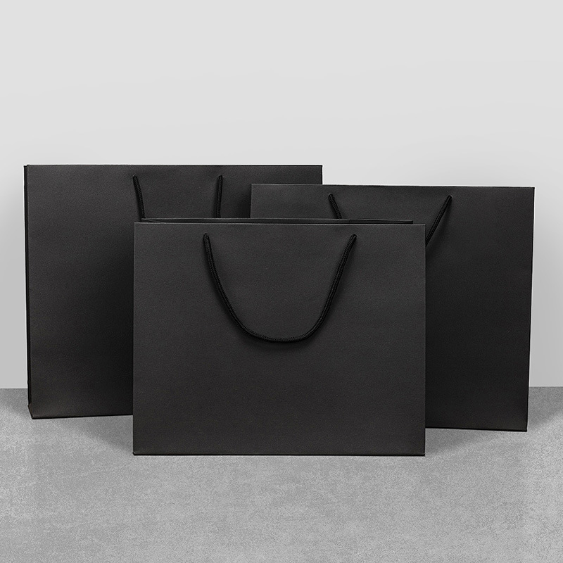Bolsa de regalo de papel Kraft bolsa de embalaje de cartón negro en stock bolso de regalo de ropa ventas directas de fábrica