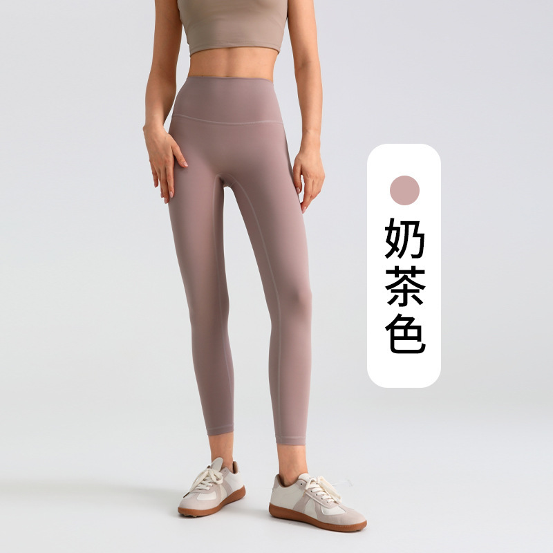 ヨガのズボンの女性は腹を収めて尻を持ちます。|undefined