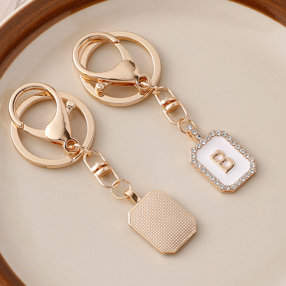 Nueva moda 26 cartas gota de diamante aceite llavero bolso del auricular pareja colgante vacaciones pequeño regalo al por mayor