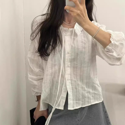 White long-sleeved shirt with floral lace and ribbon details, featuring a sweet chic early autumn vibe, paired with a knitted cabled vest.