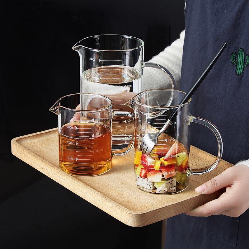 Transparent glass measuring cup scaled