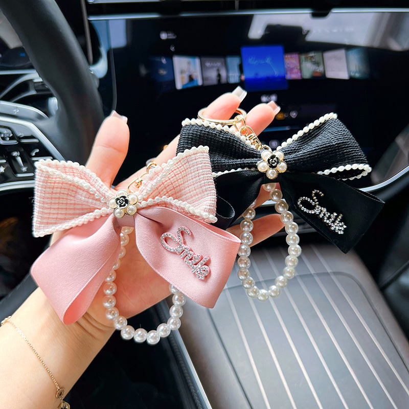 Nuevo Xiaofeng Shan camellia letra arco llavero de automóvil cadena de perlas bolsos creativos decoración colgante mujer