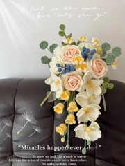 新婦の手で花を持つdiy材料は毛糸を包んで手作業でタイのバラの花束を編みます。