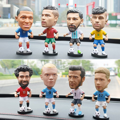 サッカーのスターの人形の車の置物は男子学生にプレゼントします。