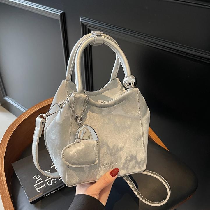 Nicho de diseño de bolsas de cubo de mano para mujeres 2025 nuevo estilo coreano bolso de hombro universal de moda retro bolso de mochila