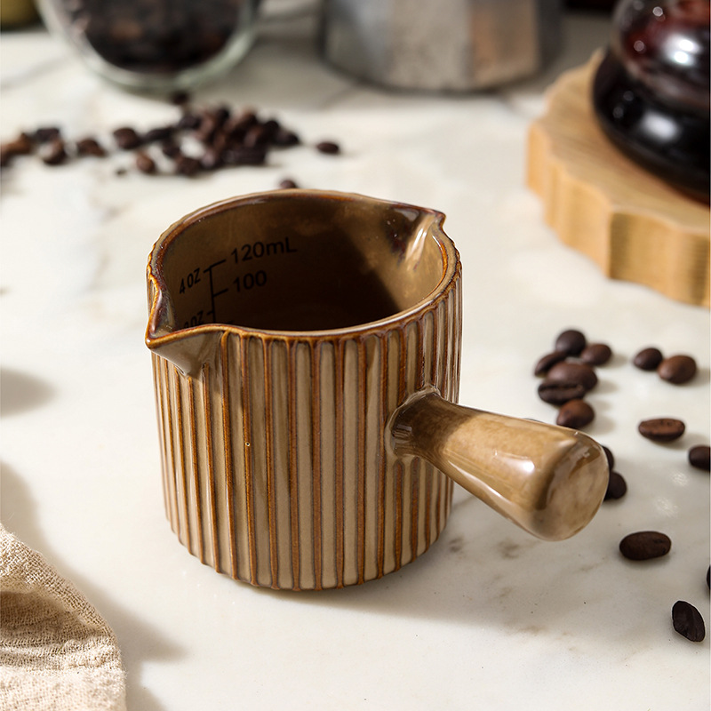 Ceramic espresso cup with handle, designed for espresso shots, featuring a dual-spout milk pitcher for Italian espresso preparation