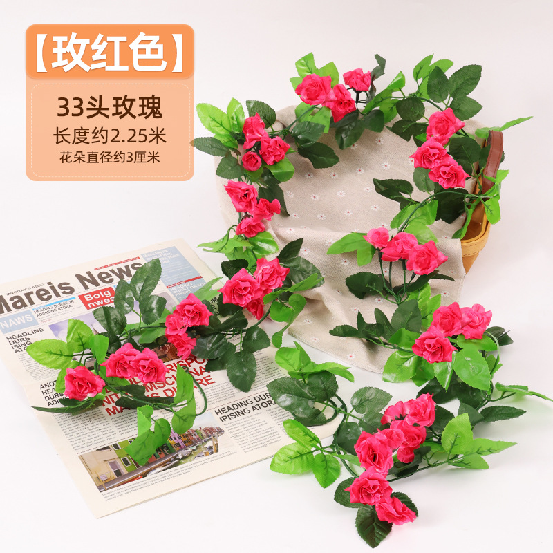 Simulación de flores falsas rosas de caña colgando la pared tubería de drenaje envuelta hoja verde que cubre la parte superior de la decoración de boda de plástico