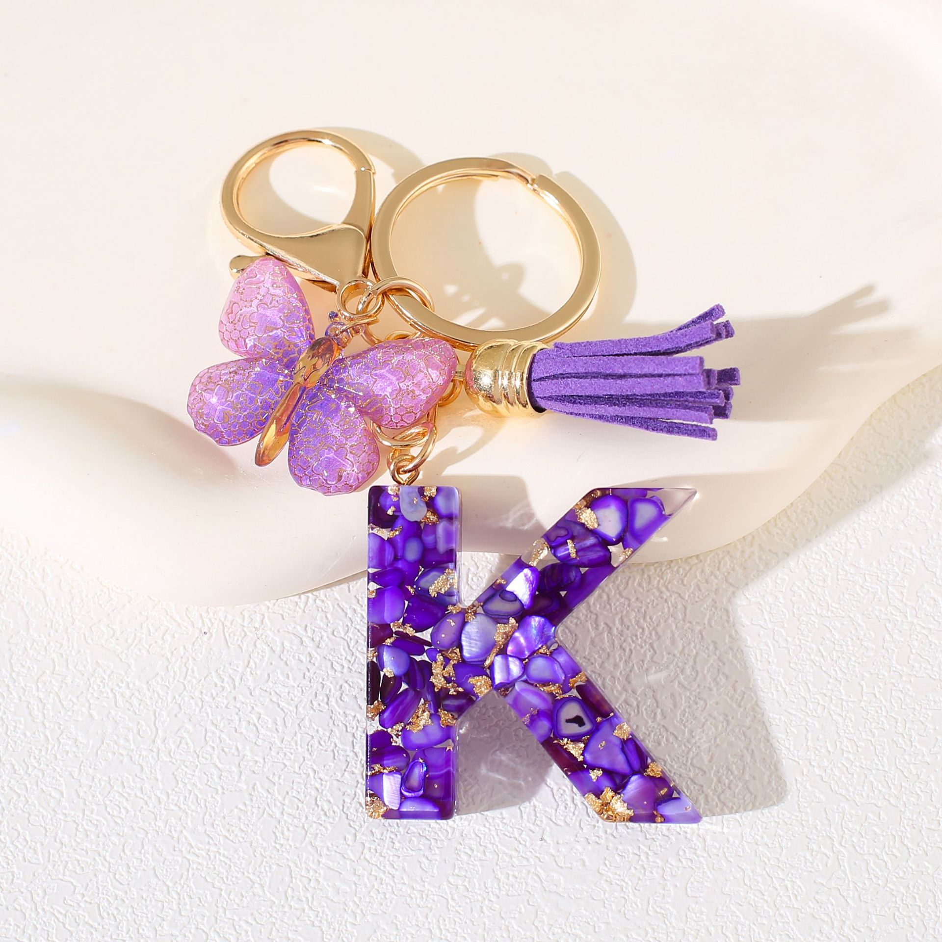 Fábrica directa de Yiwu accesorios de resina de goteo de embalaje llavero anillo de metal letras mariposa brilla colgante damas