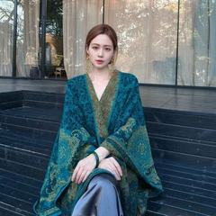 ピーコックの青いストールの外で女性の雲南新疆のチベットの大西北の旅行は写真を撮る民族風のマントを着ます。