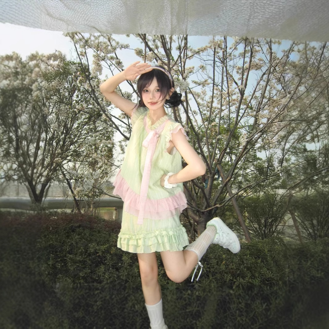 2つのセットは甘くて清純で、小柄な蝶結びのハスの葉の縁の上着の女性の緑の木の耳元の半身のスカートです。