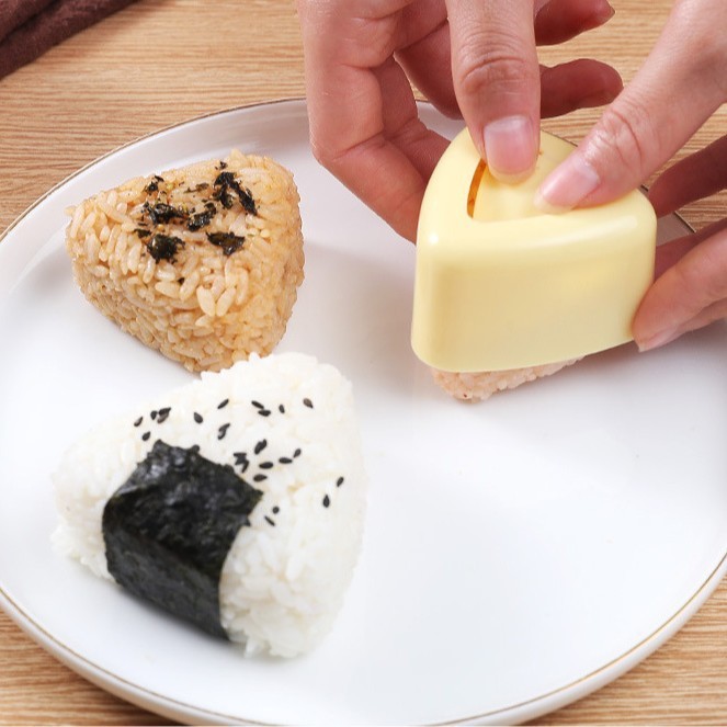 子供のおにぎりの型の海苔はご飯の三角のおにぎりの食品級の材質を包んで作ります。|undefined