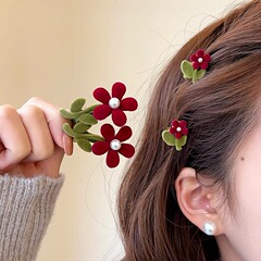 お姫様の頭の半分に赤い花のヘアピンの女性の髪の前髪のサイドに植毛の小さい花を挟みます。