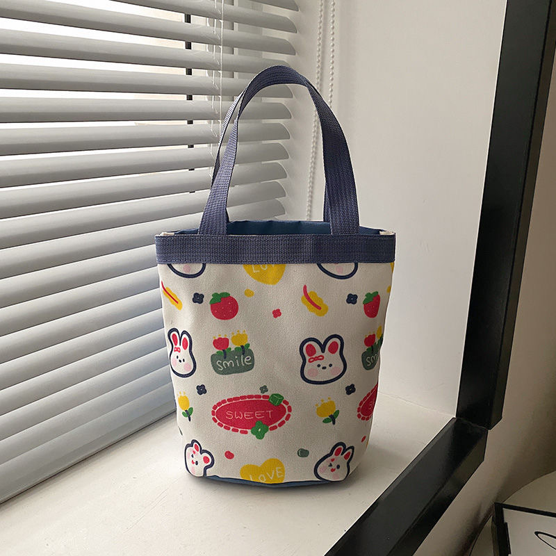 かわいい落書きバケツバッグinsプリント円筒バッグキャンバス弁当袋韓風少女は弁当箱を持っています。|undefined